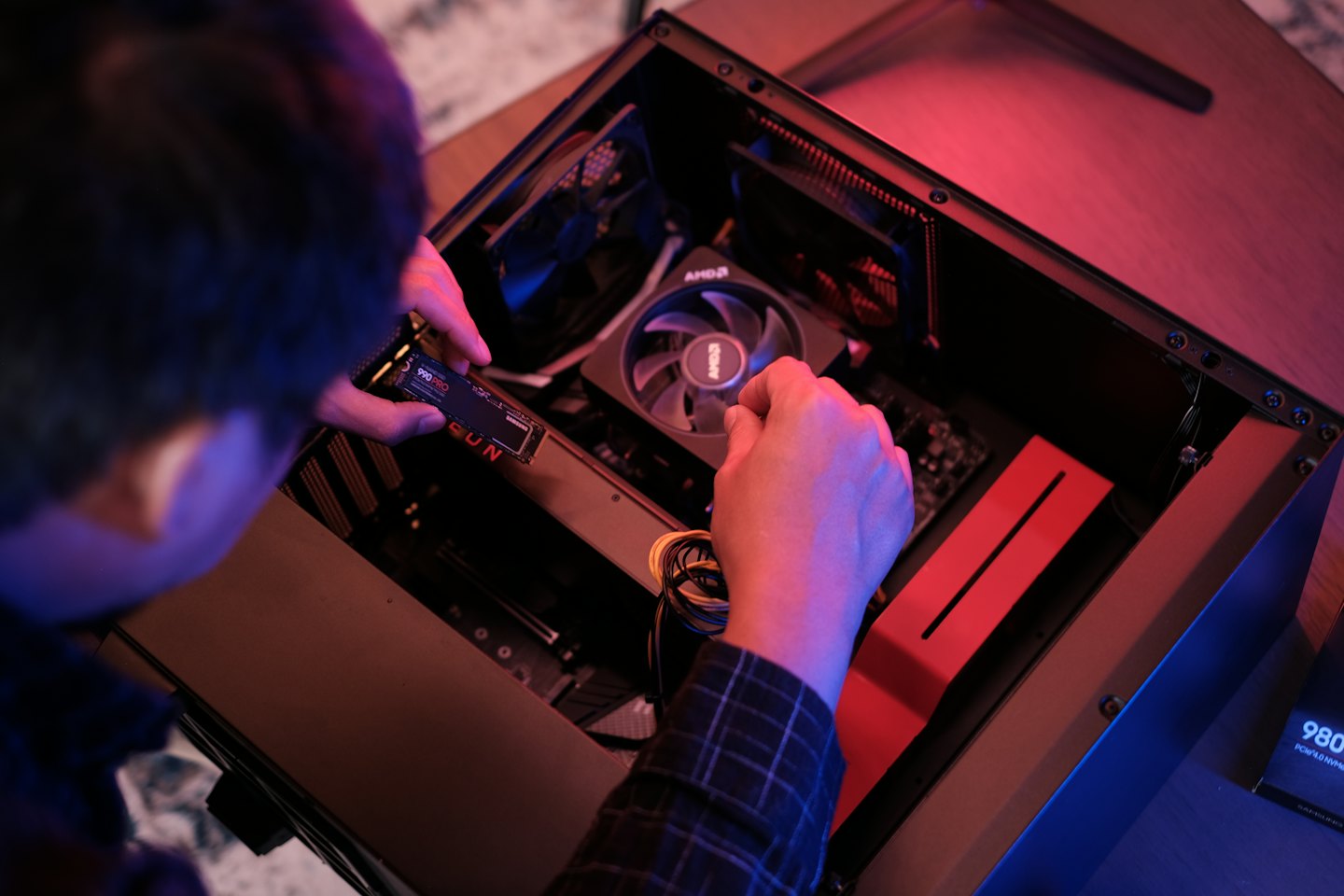 Person installing SSD into open computer case.
